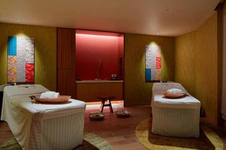 Churaku spa couples massage room with low lighting and red accents.