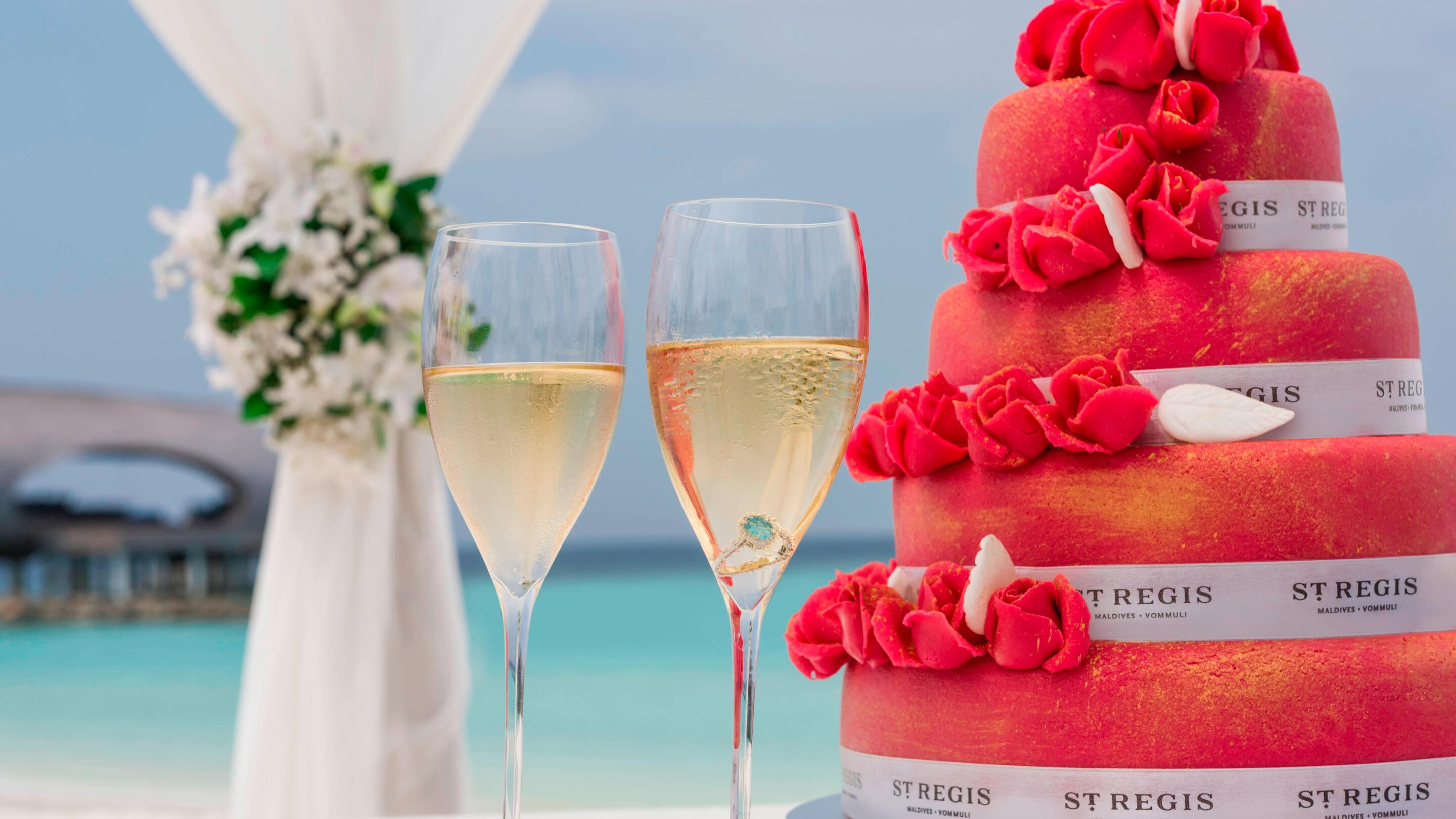 Red wedding cake, two champagne glasses overlooking the Ocean