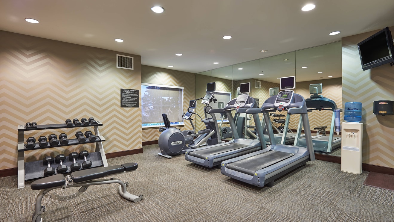 Hotel fitness room with treadmill and free weights