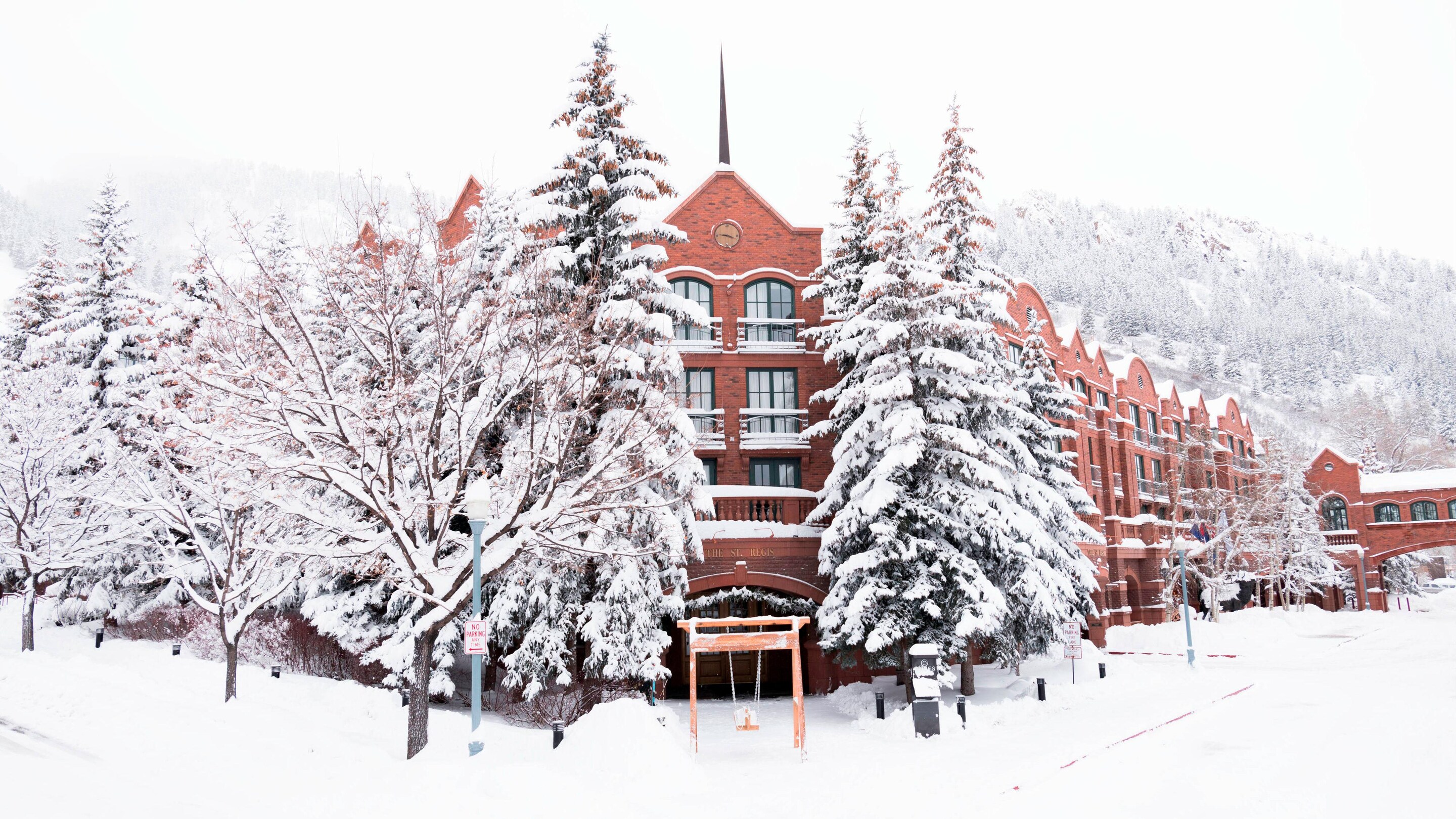 Hotel exterior surrounded by trees covered in snow