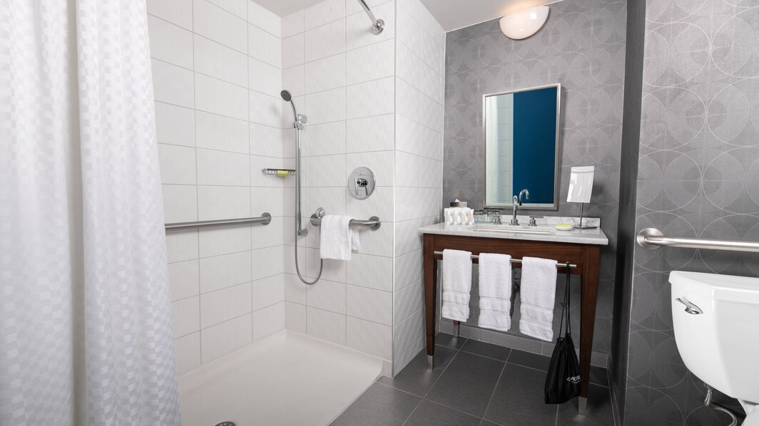 Banheiro acessível para hóspedes com mobilidade reduzida com chuveiro para cadeira de rodas