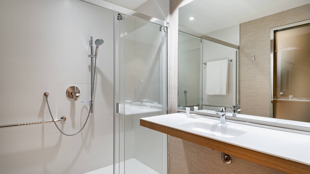 Ванная комната для гостей с ограниченной подвижностью в номере с 2 односпальными кроватями – безбарьерный душ