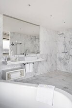 Bad einer größeren Suite – Badewanne und barrierefreie Dusche