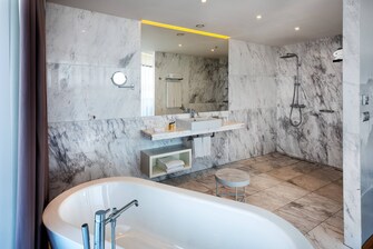 Bad einer Rooftop Suite – Badewanne und barrierefreie Dusche