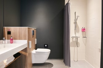 Douche accessible en fauteuil roulant d’une salle de bain de chambre Moxy accessible aux personnes à mobilité réduite