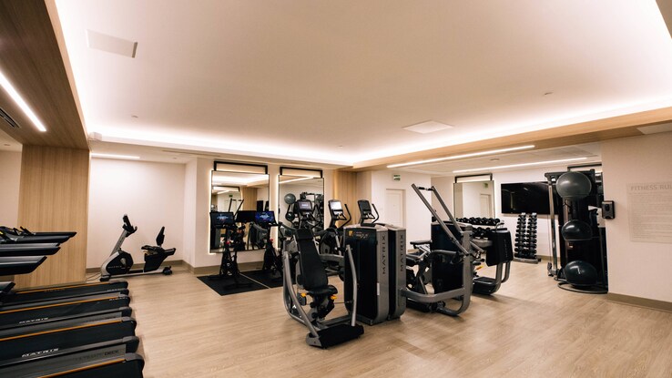 Fitness center with different equipment throughout room.