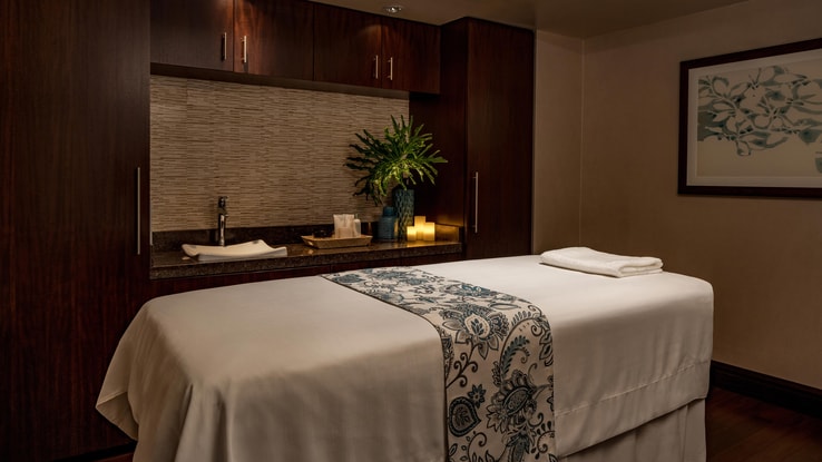 Heavenly Spa room with bed, towels, and other amenities under soft lighting and a gentle color scheme.