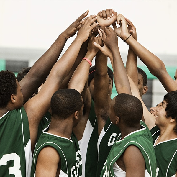 Male basketball players in a group high-five