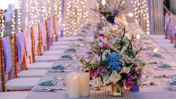 결혼식을 위해 장식된 연회 테이블을 둘러싼 작은 불빛