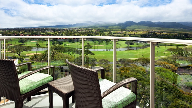 Premium Resort View guest room balcony with two chairs overlooking a golf course.
