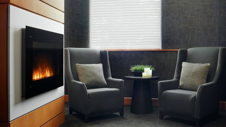 Two chairs in room next to a fireplace.