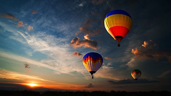 Balões de ar quente no céu do entardecer