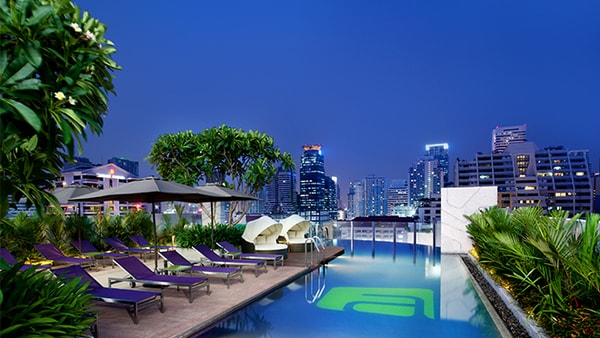 Deck da piscina com vista noturna de Bangkok
