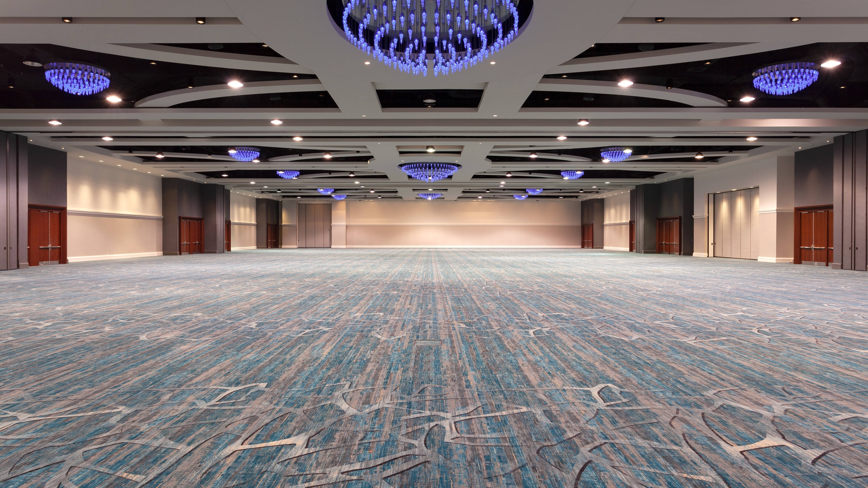 Large empty ballroom with blue lights above.