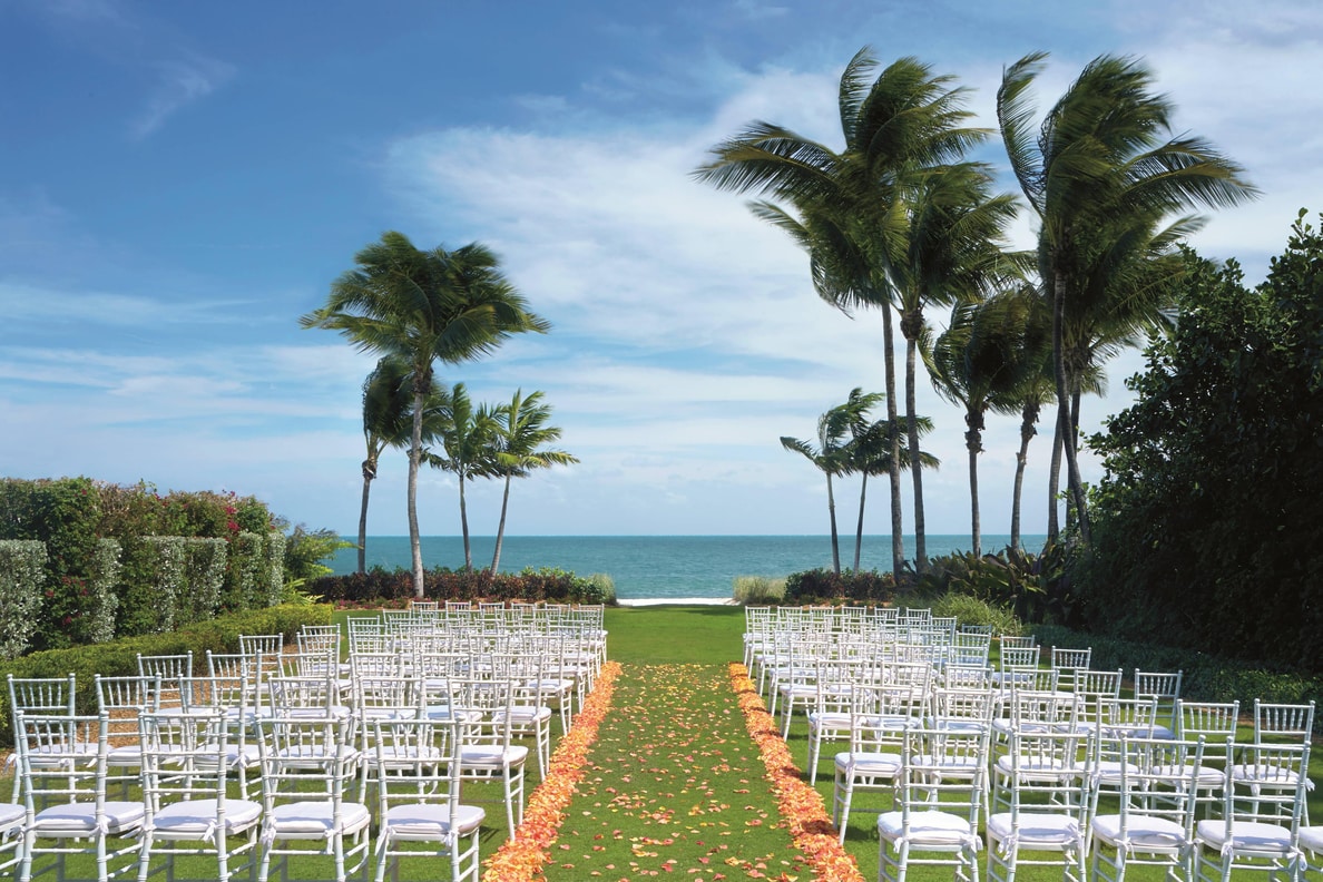 A large outdoor wedding area with many rows of chairs.