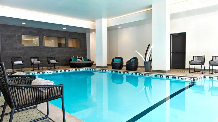 Indoor swimming pool with chairs around the perimeter. 