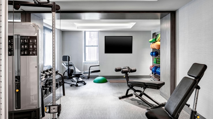 Fitness room with weights and different workout equipment.