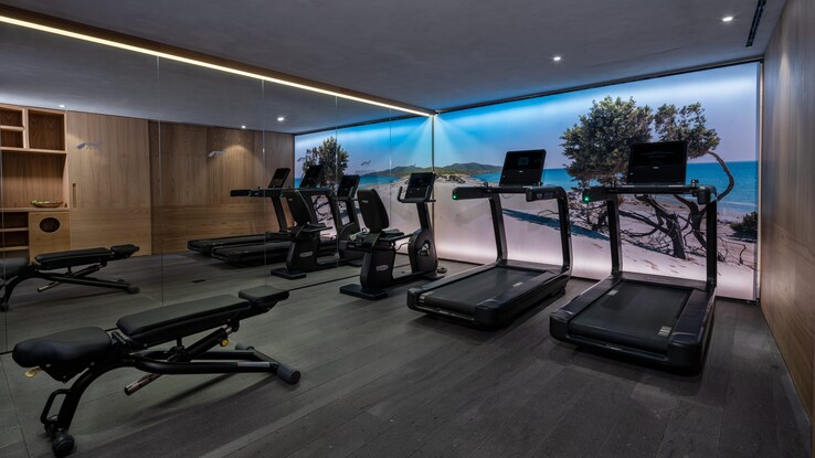 Cardio equipment and a weight bench inside the fitness center.