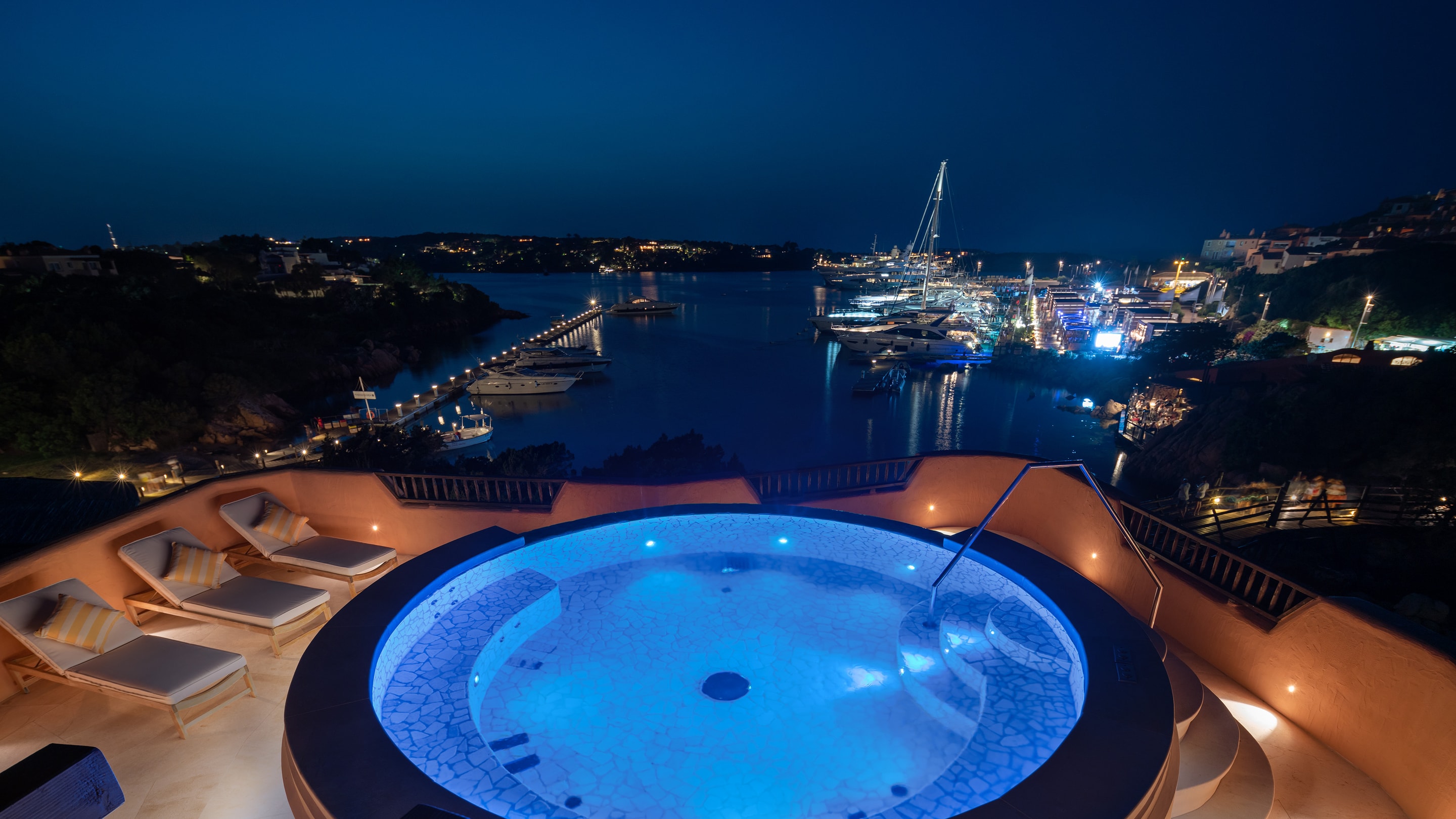 Rooftop jacuzzi with view of city lights.