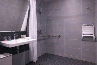 Salle de bain accessible aux personnes à mobilité réduite, douche accessible en fauteuil roulant