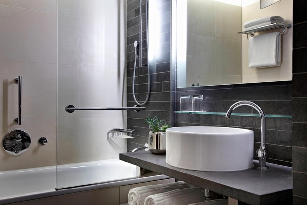 Bathroom with bathtub, sink with mirror and towels