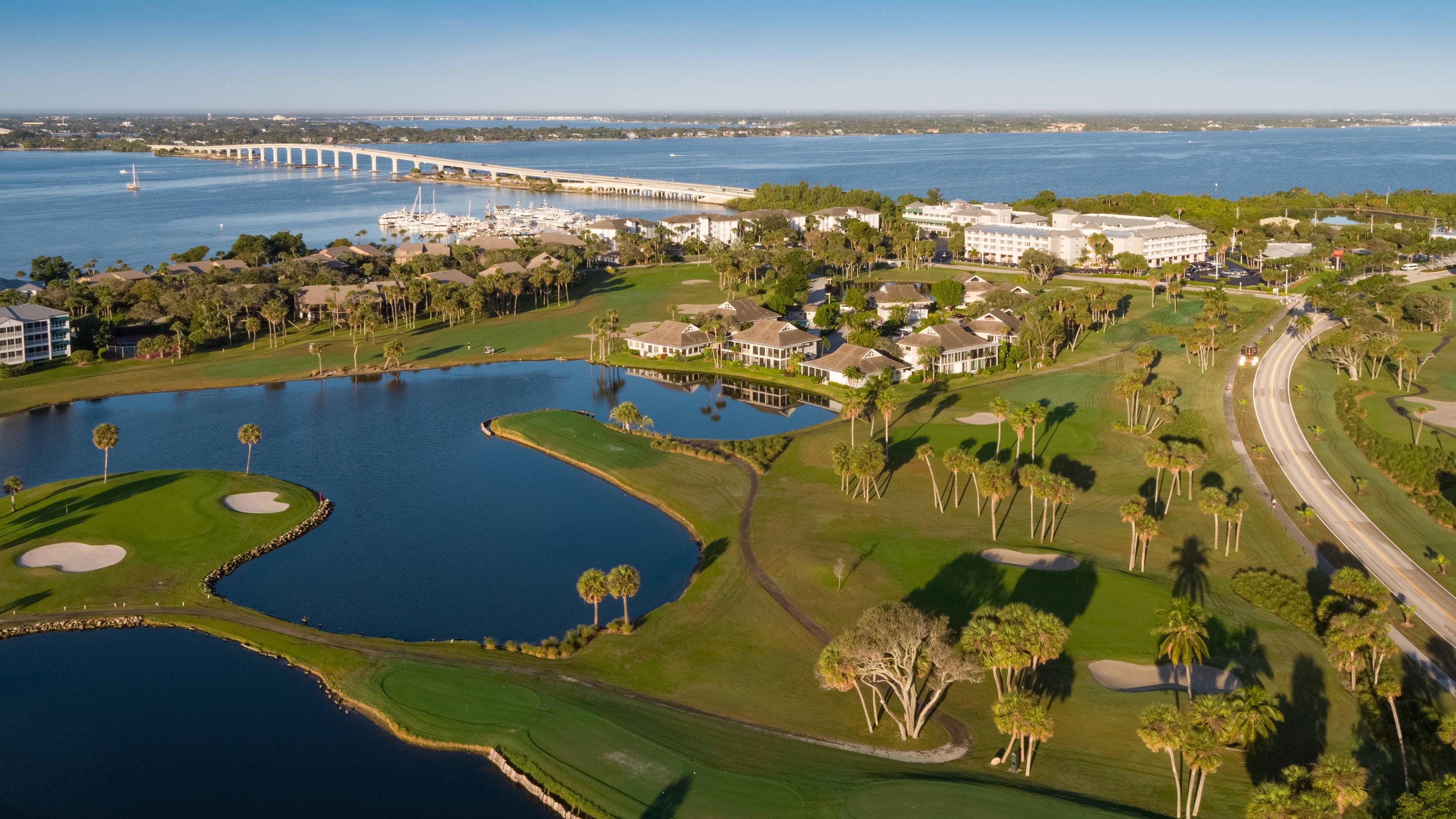 Aerial of golf course, marina, resort grounds and ocean. 