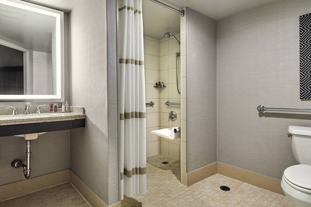 Banheiro para hóspedes com mobilidade reduzida com chuveiro para cadeira de rodas