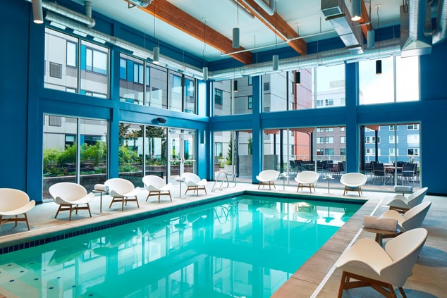 Indoor pool surrounded by windows & natural light.
