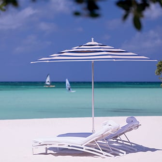 Luxury resort beach chairs on a white sand beach in Aruba.