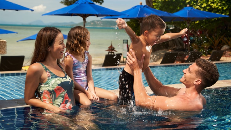A family enjoys their time together poolside.
