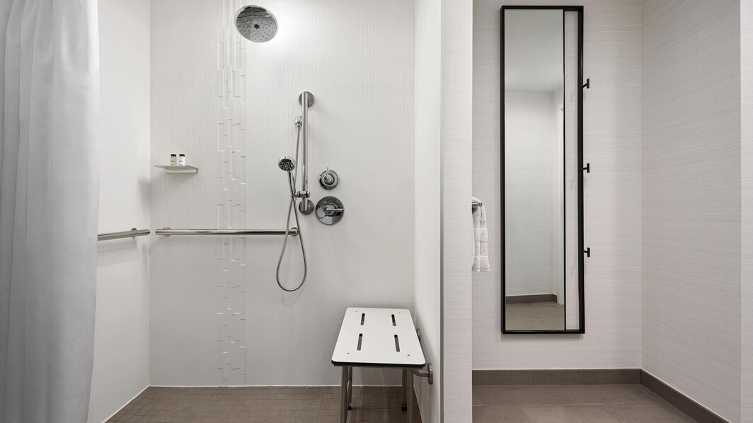 Banheiro de quarto para hóspedes com mobilidade reduzida  Chuveiro para cadeira de rodas