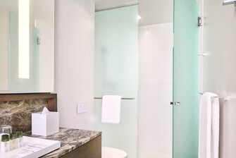 Salle de bain de chambre avec deux lits queen size, douche à l’italienne