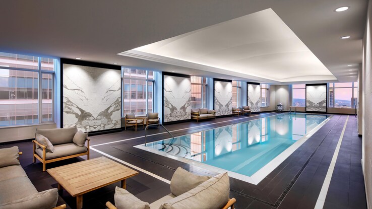 Indoor heated pool with lounge chairs.