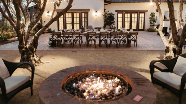 Outdoor wedding table layout alongside a firepit