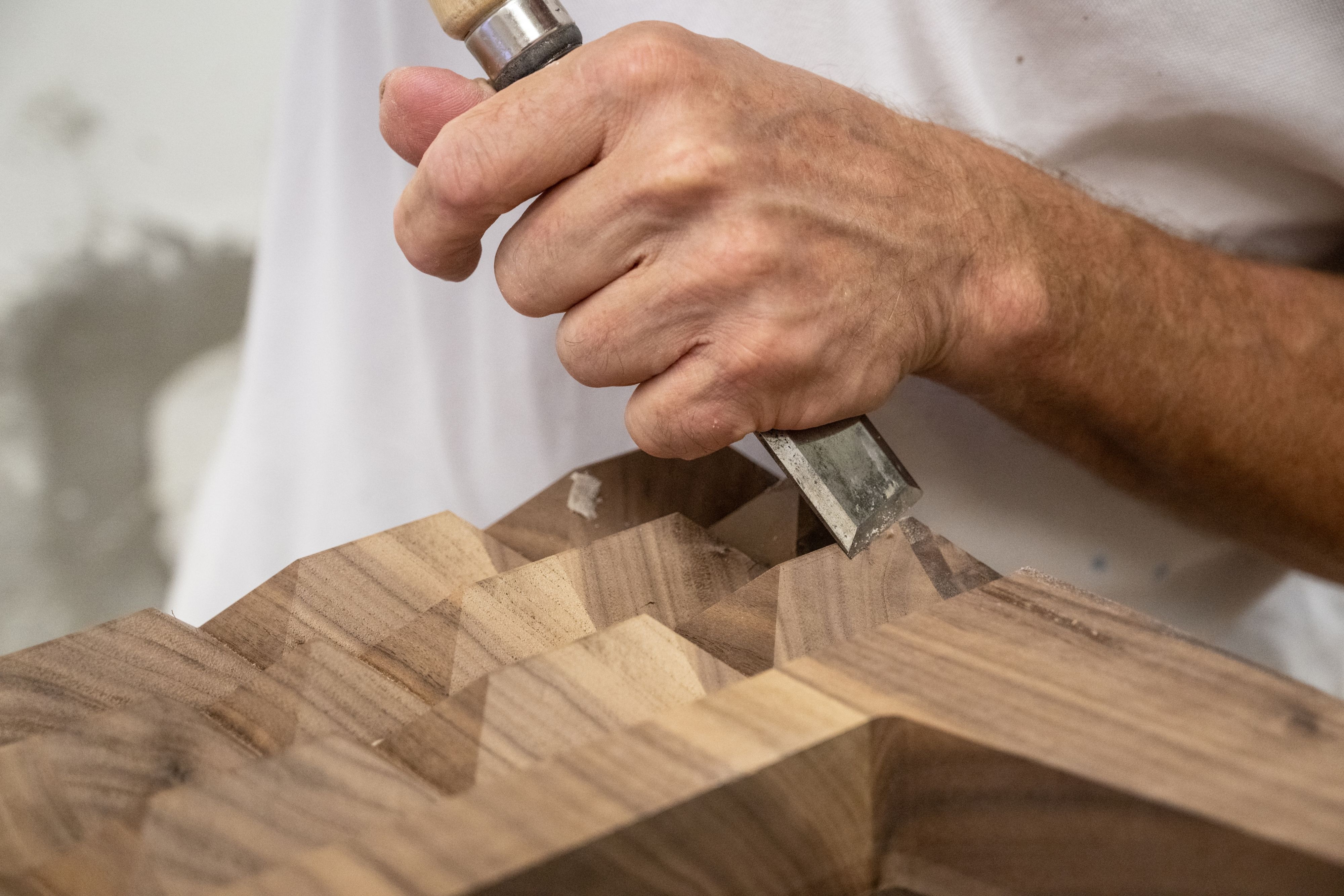 A crafsperson carving wood