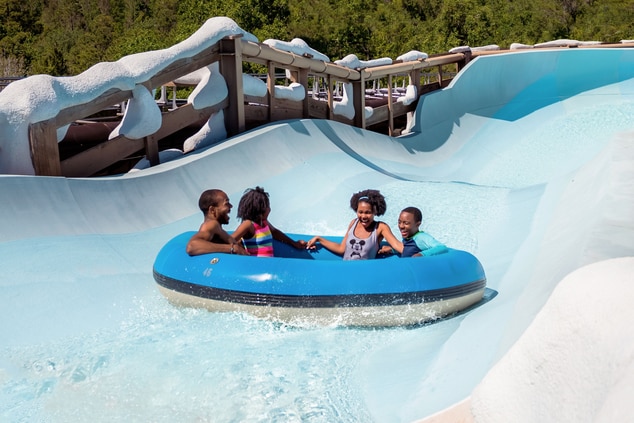 Family laughs while on waterslide.