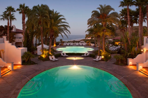 Pools and palm trees with beach in the background