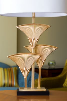 Lamp displaying three gold fans of varying heights as its base