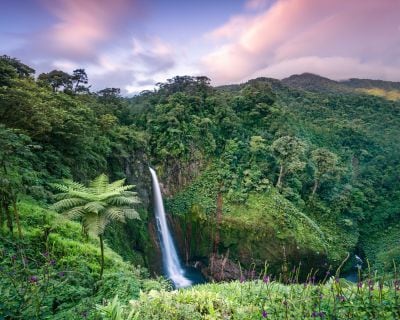 Sunset over waterfall in the green forest of Costa Rica