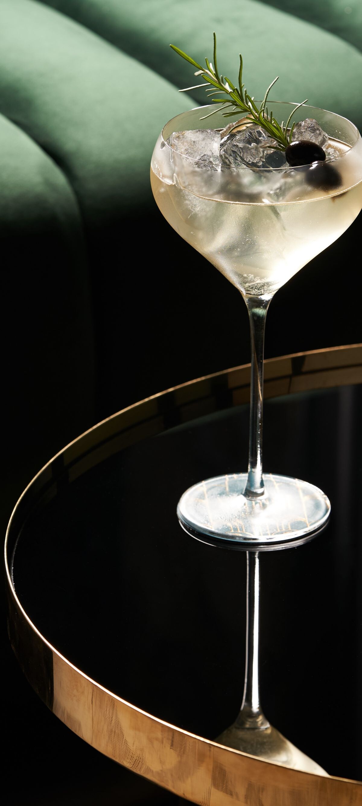 Classic cocktail glass on glass table in night club restaurant, close-up