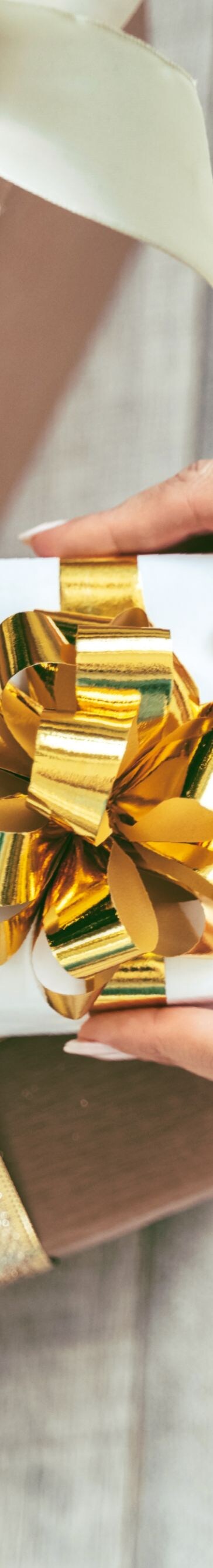 Soft woman hands putting gift box under the Christmas tree