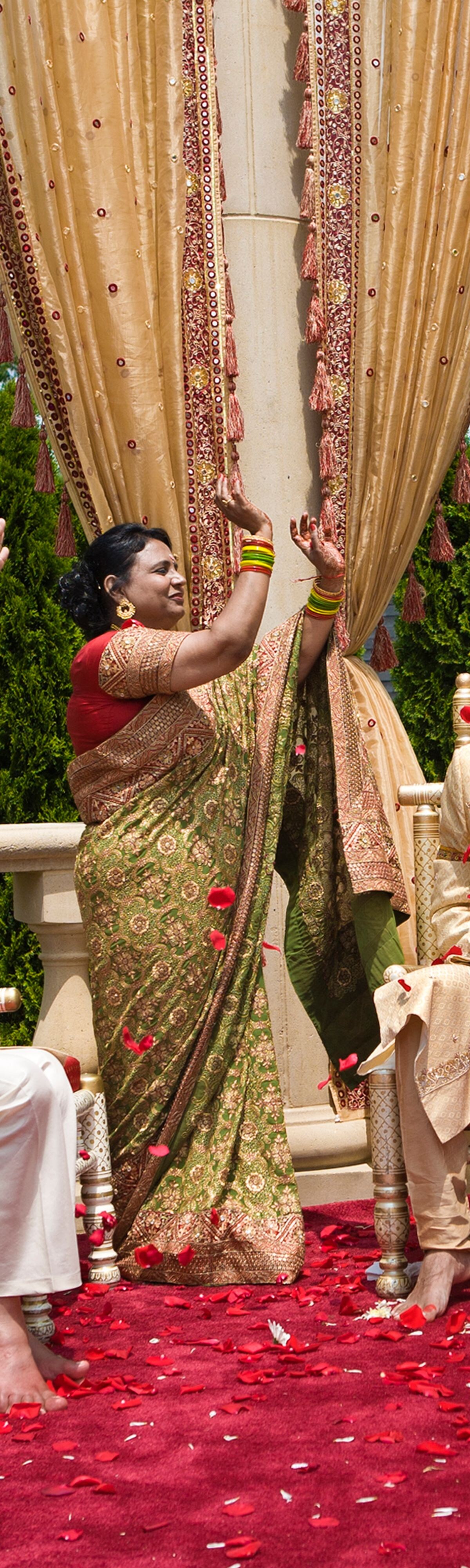 30-34 years, 35-39 years, 55-59 years, 60-64 years, altar, arms raised, beginnings, bride, brother, celebration, ceremony, color image, commitment, daughter, day, energy, enthusiasm, father, flower, full length, future, gold, groom, happy, head and shoulders, heritage, heterosexual couple, hope, horizontal, husband, indian ethnicity, large group of objects, life events, love, man, mandap, marriage, mature adult, mature women, medium group of people, mid adult, mid adult men, mid adult women, mid-air, milestone, mother, motion, nature, new jersey, ornate, outdoors, people, petal, photography, red, rockleigh, romance, rose, senior adult, senior men, sister, sitting, smiling, son, standing, sunny, throwing, together, tradition, traditional clothing, traditional culture, travel, united states, vitality, wedding, wedding dress, well-dressed, wife, woman