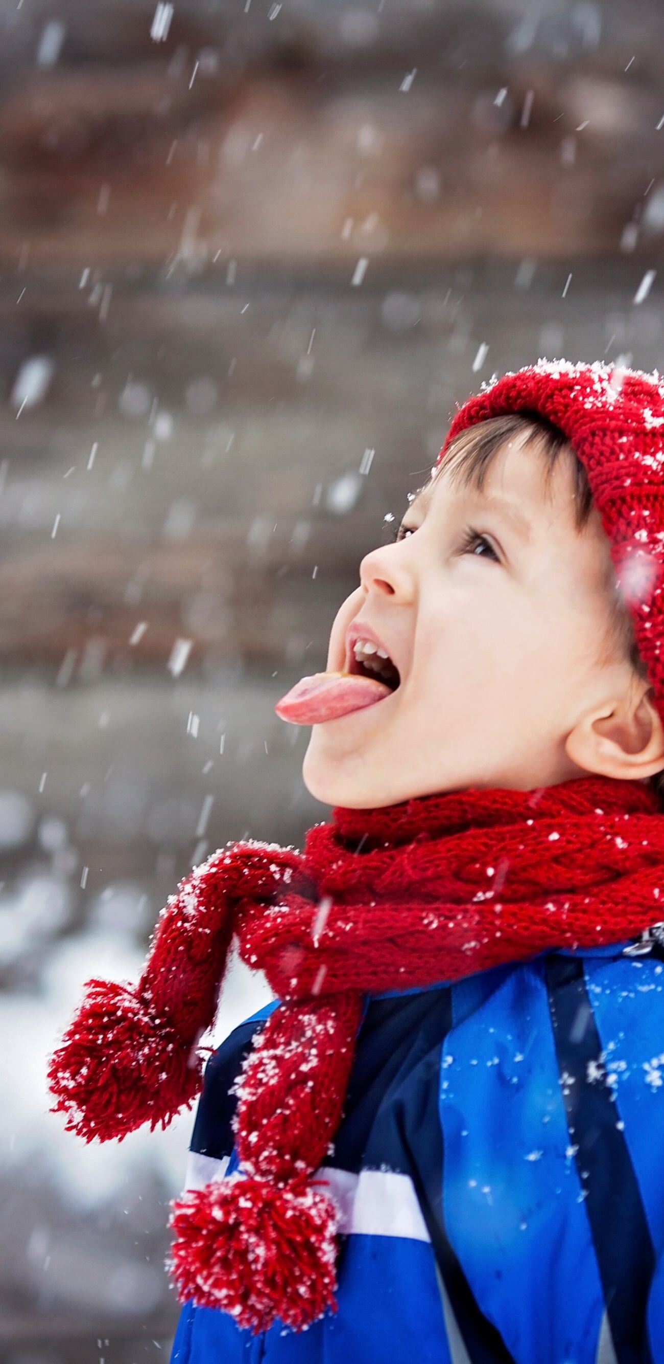 Close portrait of little boy, catching snowflakes