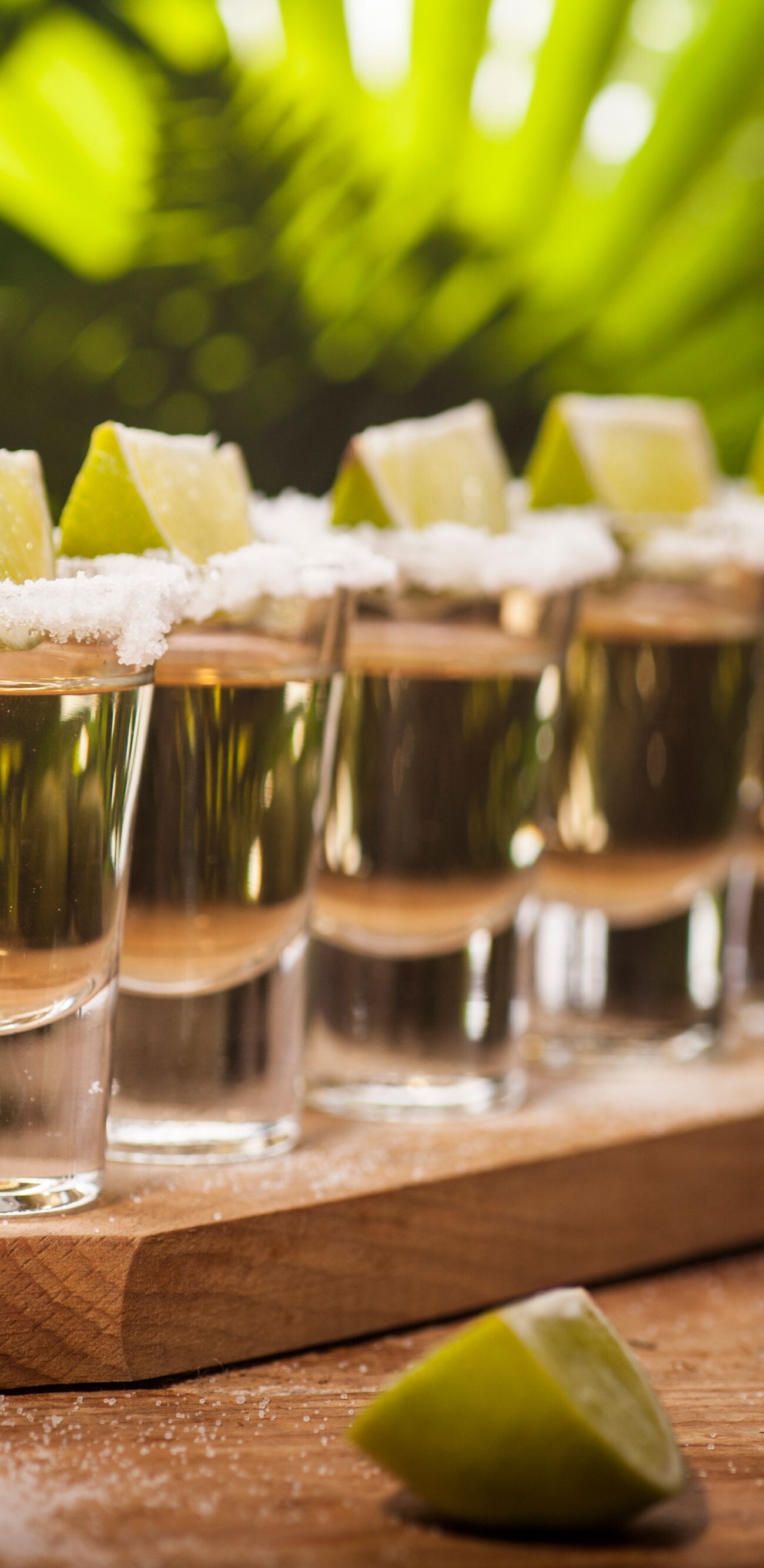 Gold tequila shots with lime fruits