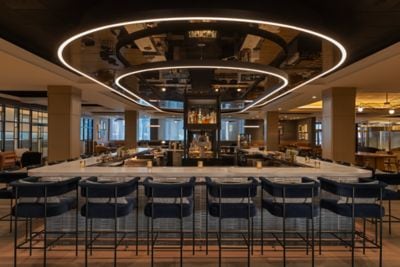 Large, rectangular lobby bar surrounded by chairs
