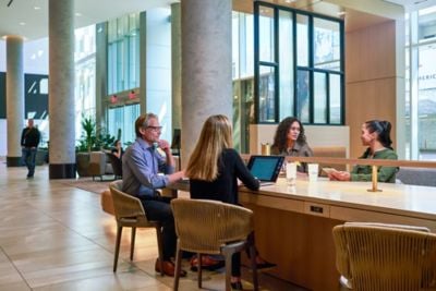 Colleagues working at a community table in lobby