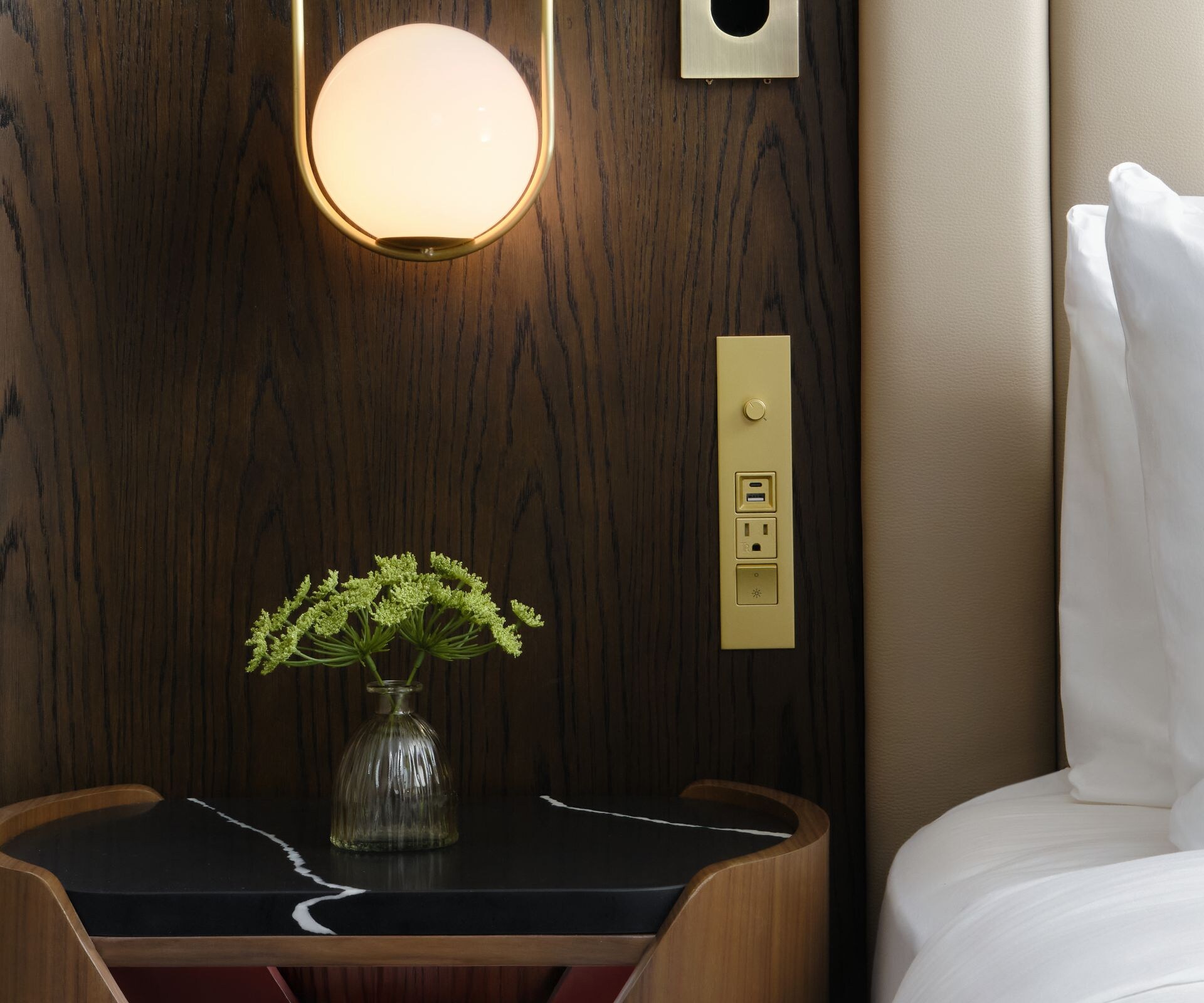 Nightstand next to bed with light above it