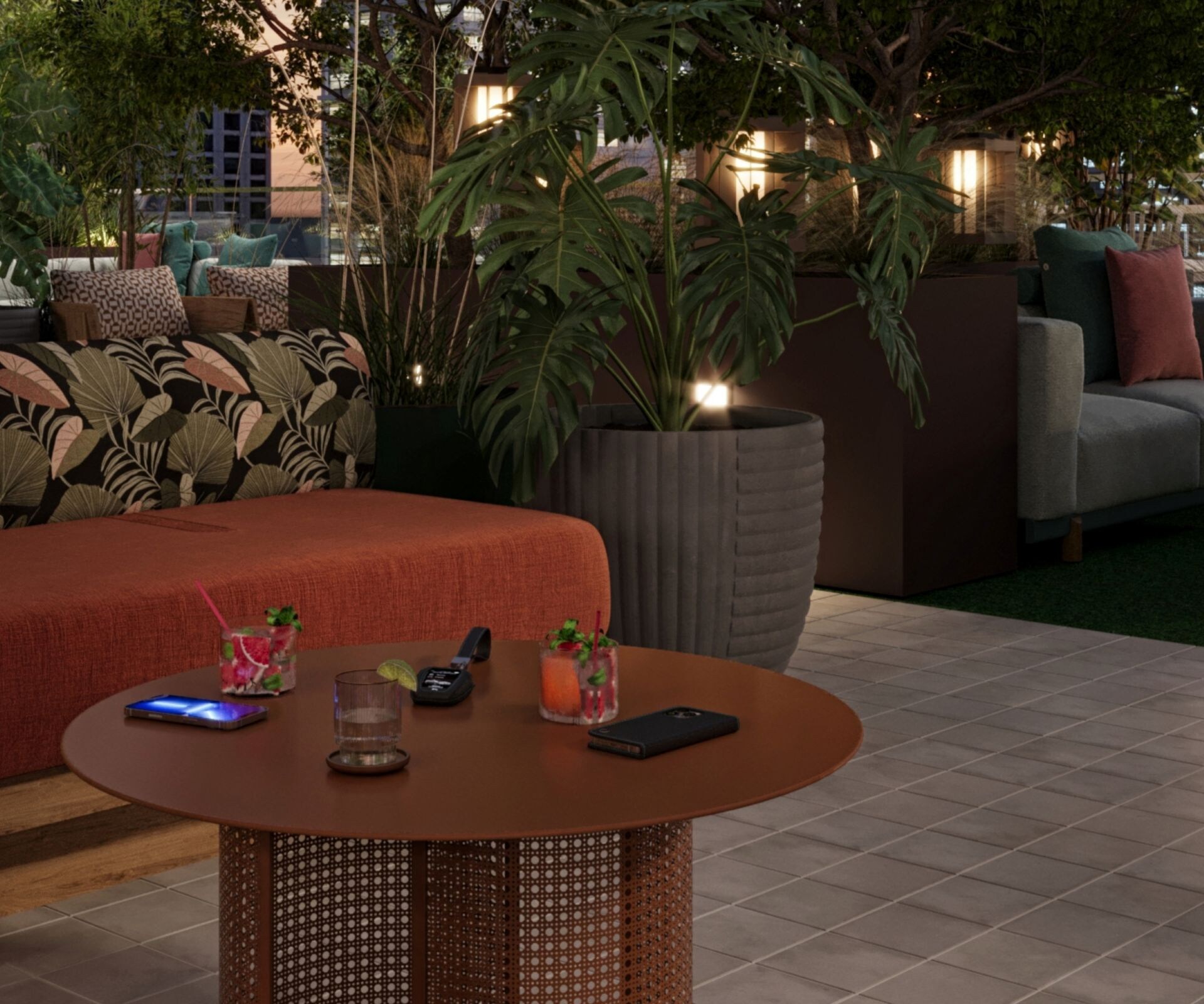 Couch and table on rooftop with greenery around