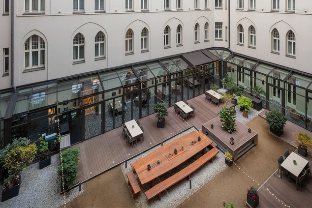 Hotel courtyard with benches, chairs and bushes  
