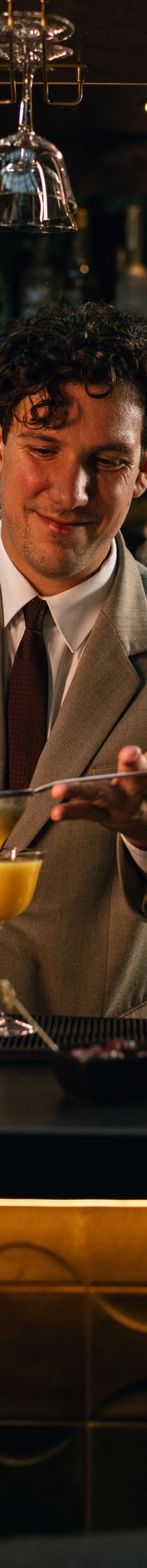 A bartender carefully pours a freshly prepared coc